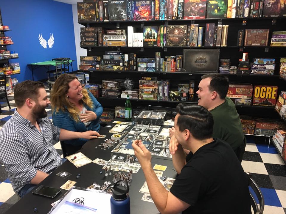 Four people playing a table top role playing game at Zanders Game House.