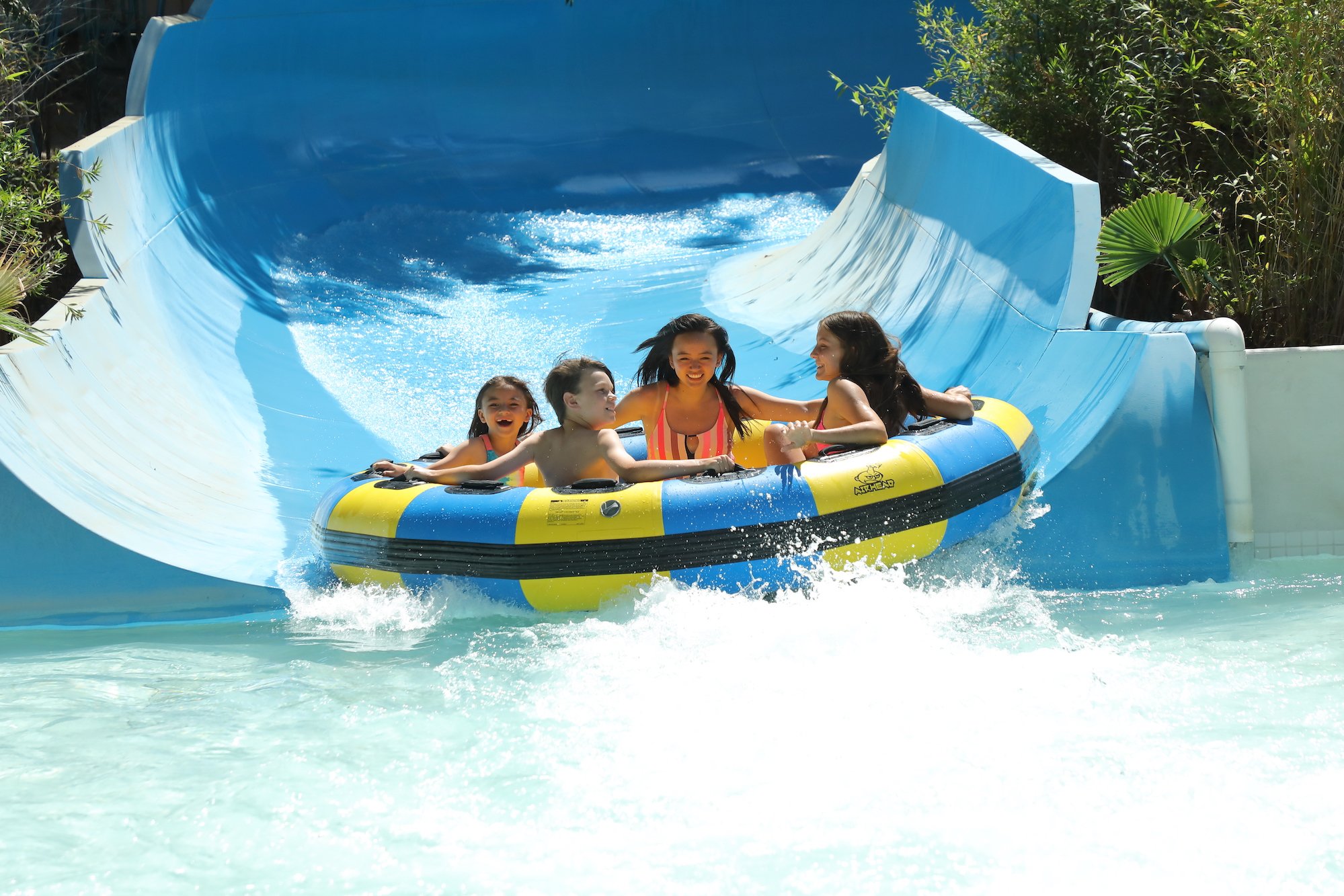 4 young park visitors riding the Lost Temple Rapids at Six Flags Magic Mountain.