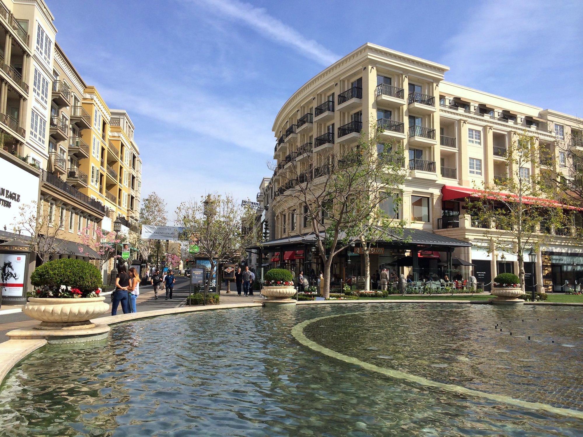A large fountain with shops and dining surrounding it