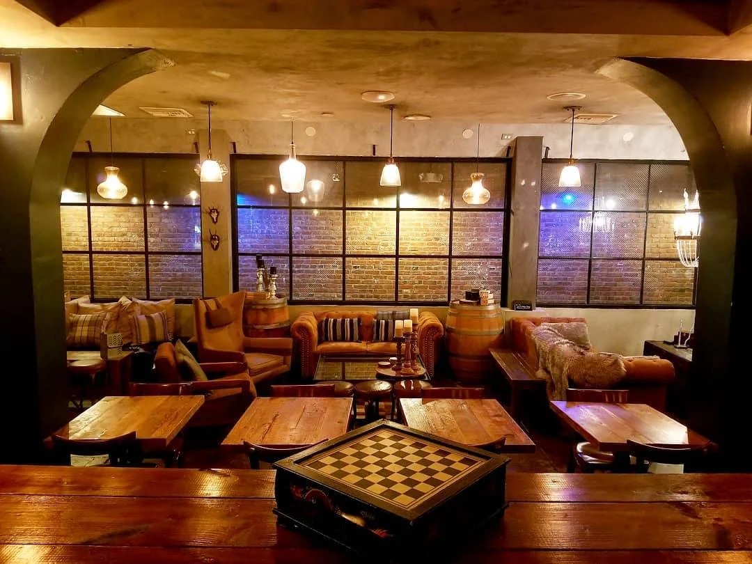 Inside the bar showing tables and comfortable seating. A chess board sits on the bar.