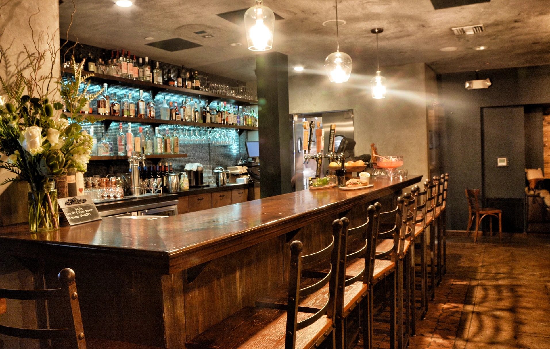 Long wood bar with seating at The Burrow