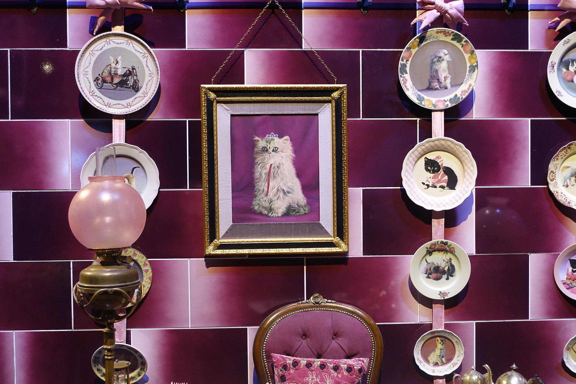 Purple tiled wall decorated with cat plates