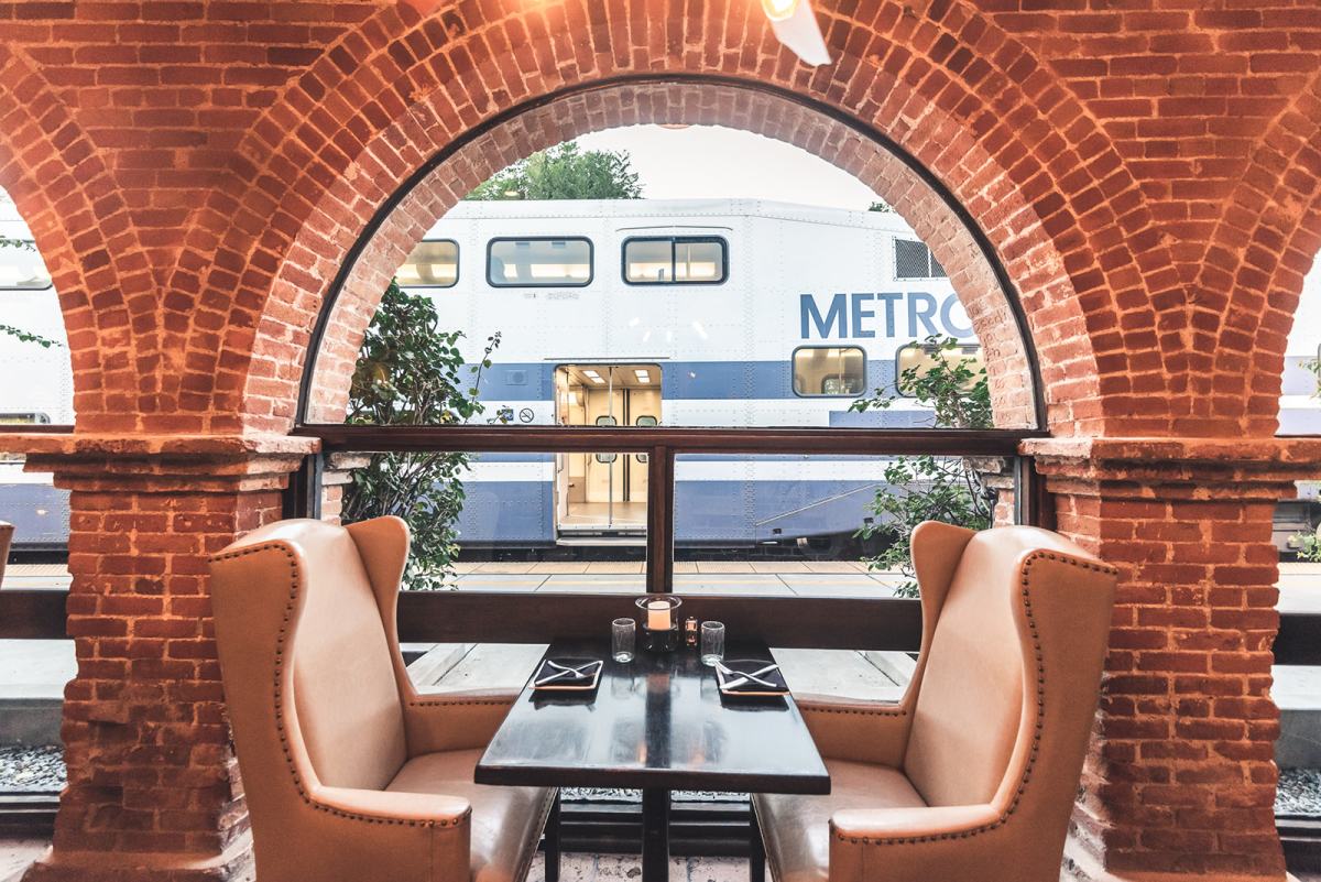 Table at Trevors next to a large window with a Metrolink train in the background