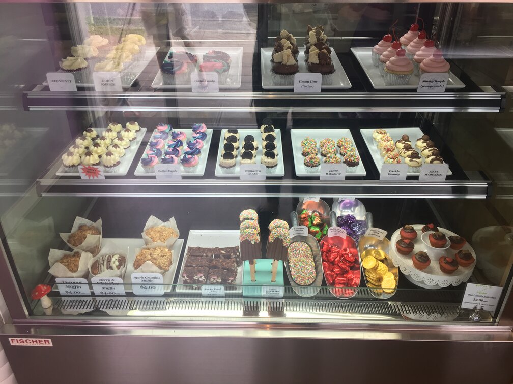 Display case full of sweet deserts atThe Cupcake & Espresso Bar
