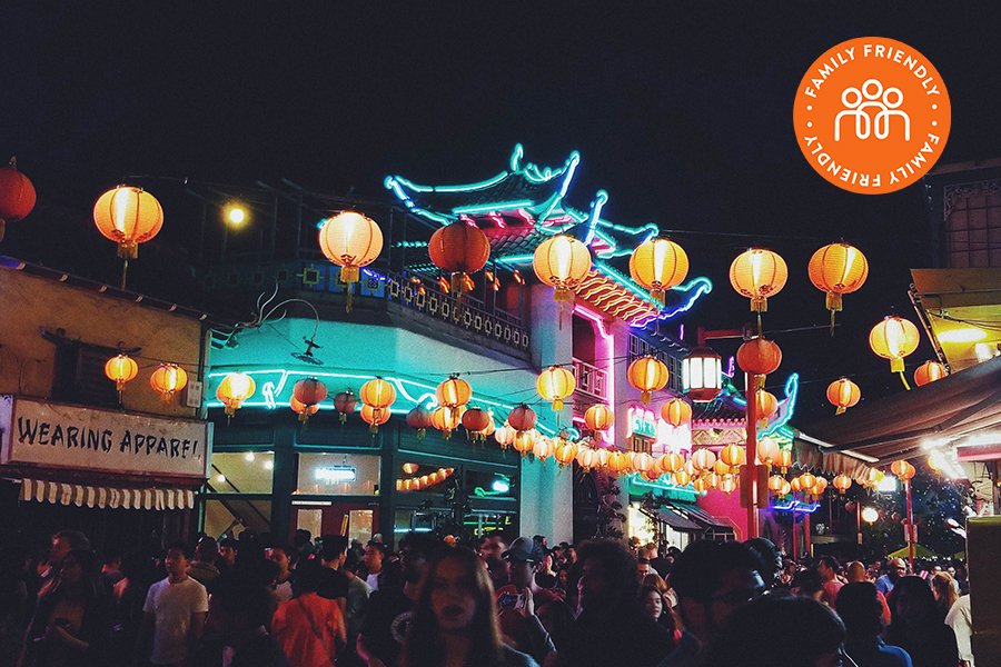 Chinatown at night lit with neon lights and paper lanterns.Image stamped with Family Friendly Badge