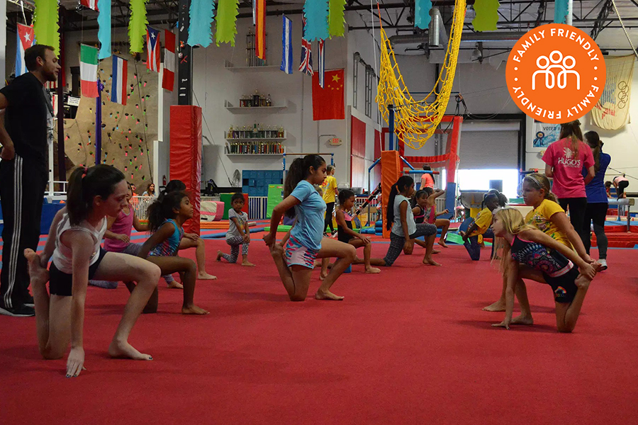 Students stretching at Hugo's Gymfitness. Image stamped with family friendly badge.