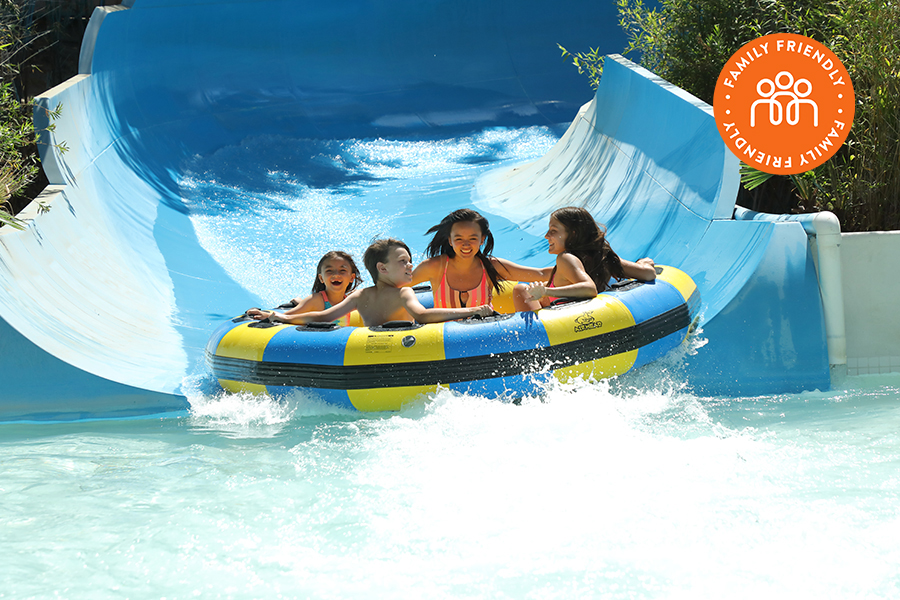 Riders on the Lost Temple Rapids at Six Flags Magic Mountain.  Image stamped with Family Friendly badge.