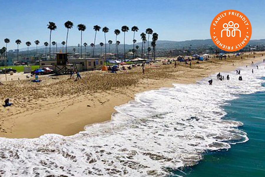 Aerial view of sand and waves in Newport Beach. Image stamped with Family Friendly banner