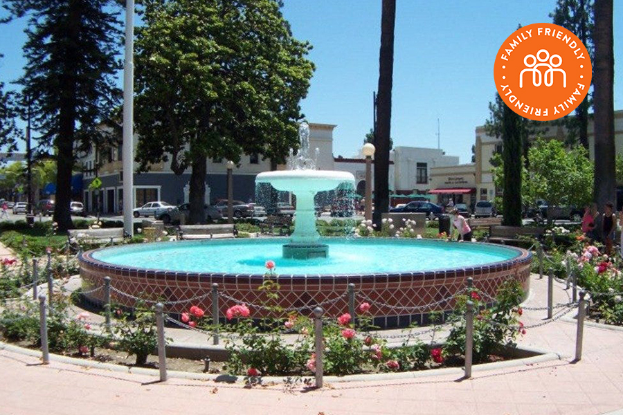 Fountain in the center of Plaza Square Park.  Image is stamped with Family Friendly badge.