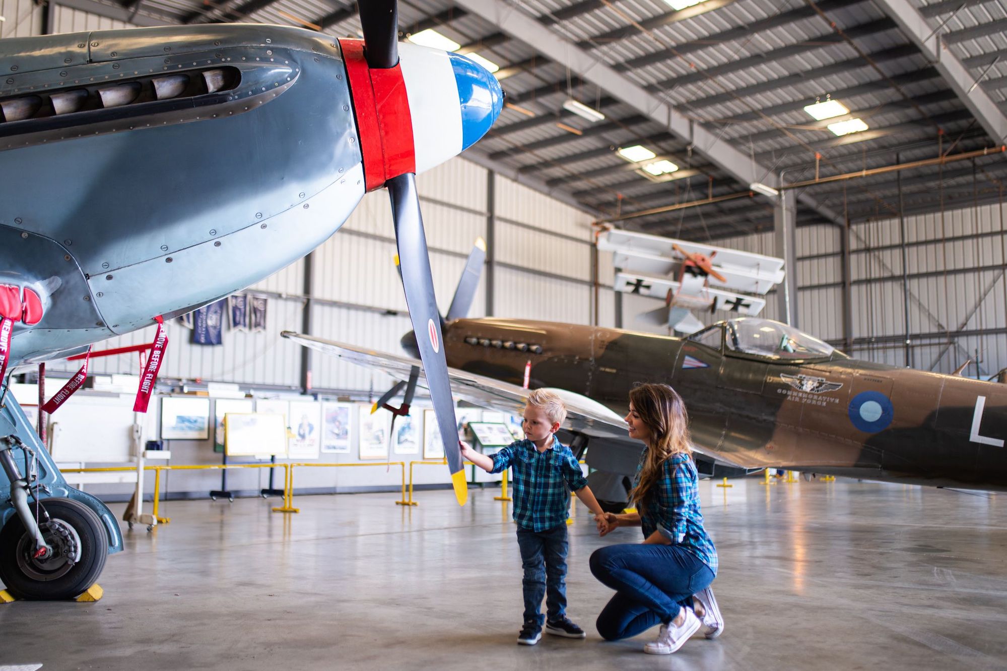 Woman and child looking at a plane at The Commemorative Air Force Southern California Wing