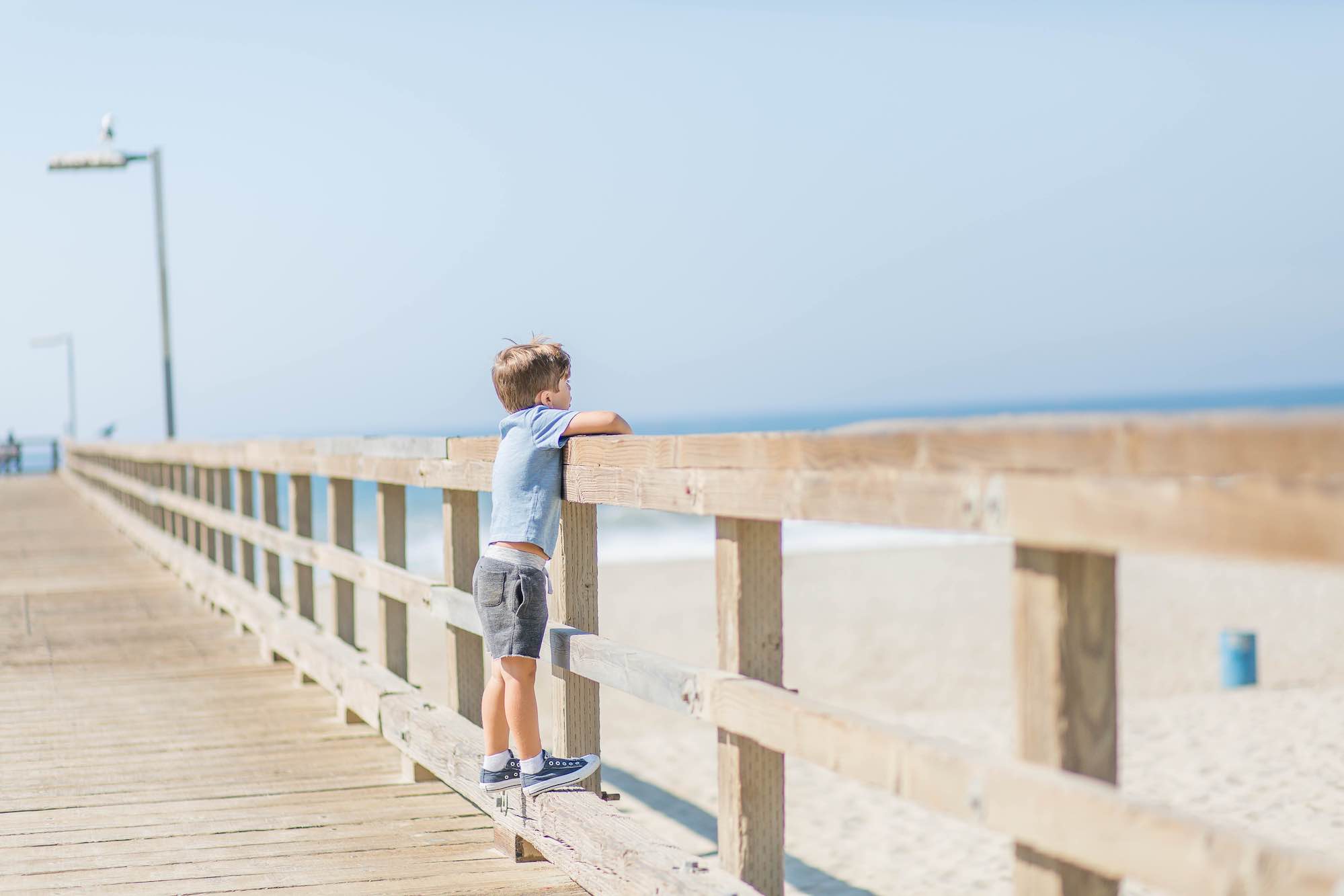 Young boy looking over the rail at Port Hueneme Pier.
