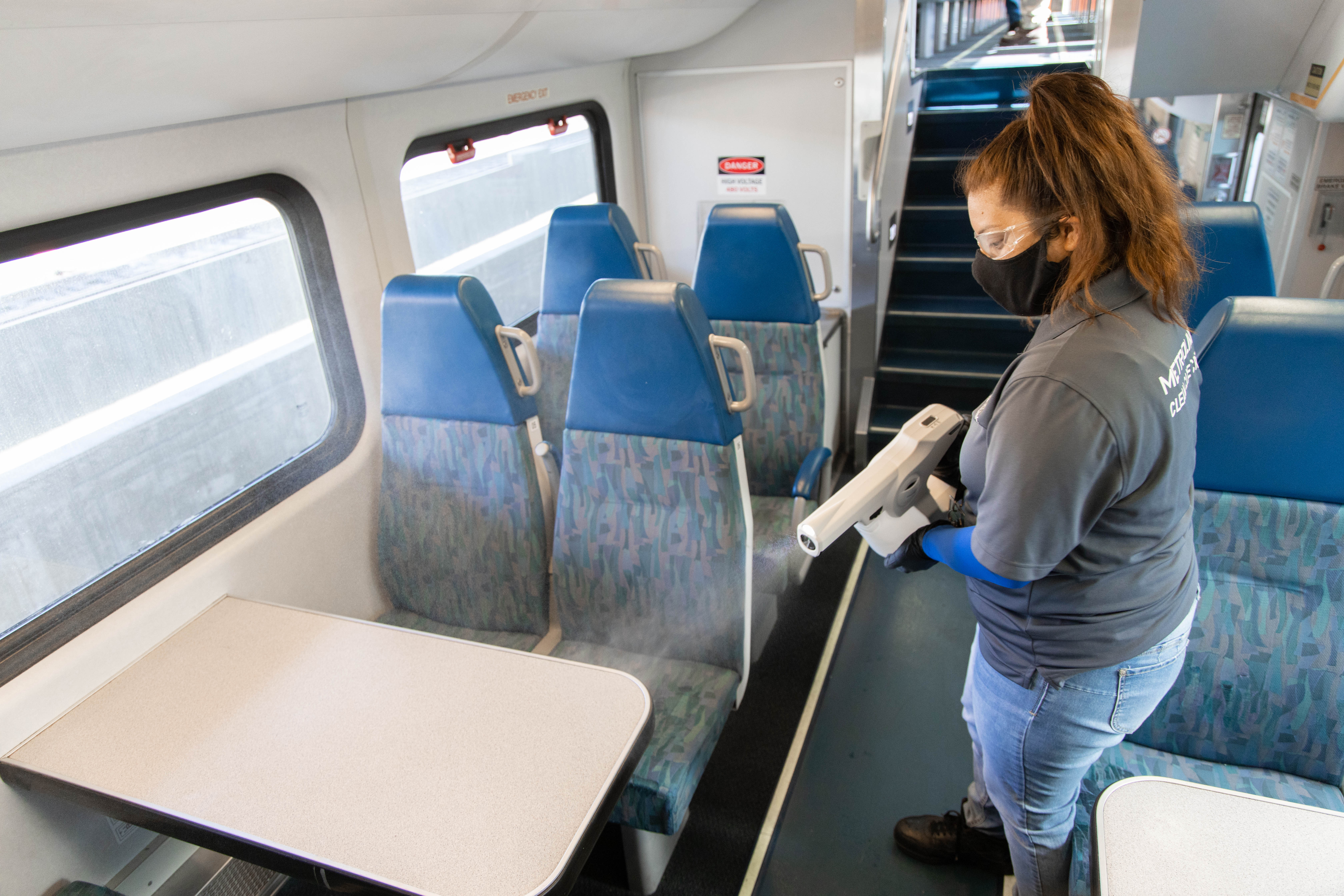 Metrolink employee using cleaning machine on train